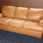 Tan Leather Sleeper Sofa With Double Stitched Seams And Studs Along Edges