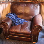 Brown Leather Like Sofa Chair With Stud Trim Along Edges