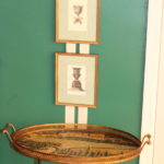 Stacking Tray Table With Hanging Artistic Prints In Gold Frames