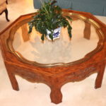 QUALITY OCTAGONAL WOOD COFFEE TABLE WITH DETAIL CARVING AND BRASS/GLASS TRAY TOP + PLANT