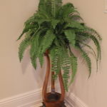 Vintage Wood Plant Stand With Copper Colored Pot Filled With Faux Fern