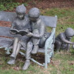 Bronze Garden Sculpture Of Children Reading On Bench With Small Child & Dog